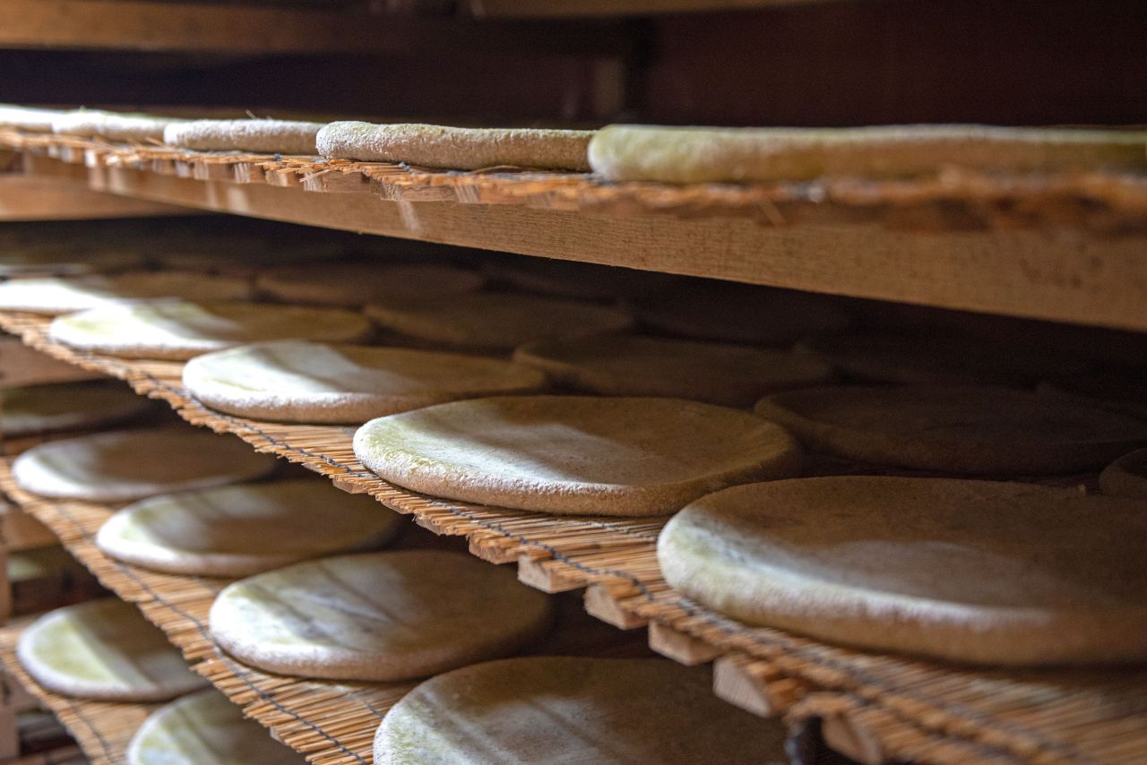 Round nuruk cakes resting on layered wooden drying racks